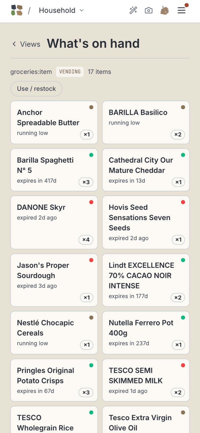 The same groceries on a phone: one card per item with its photo, quantity, where it is kept and a low badge.